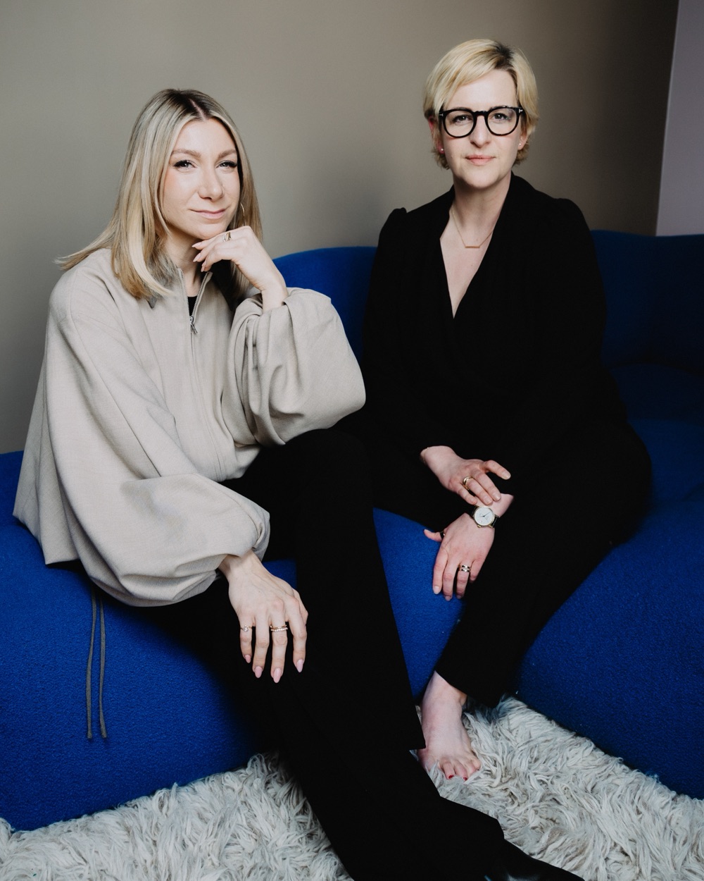 Ann-Katrin Schmitz und Carsta Maria Müller, die Hosts des Baby Got Business Clubs, auf einem blauen Sofa